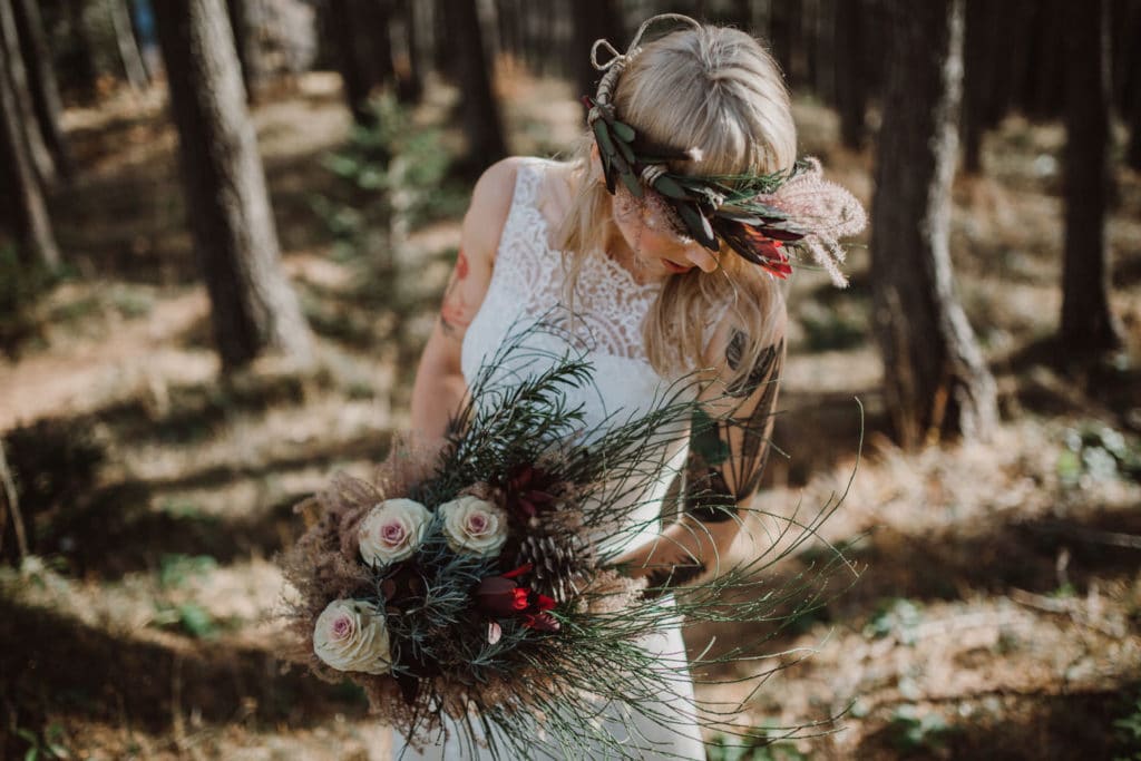 Nevesta s poročnim šopkom in venčkom v gozdu