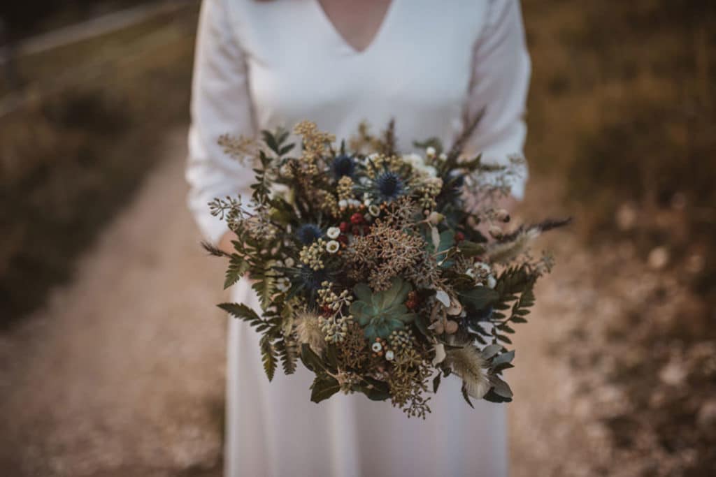 nevesta drži v roki poročni šopek gorski poročni šopek